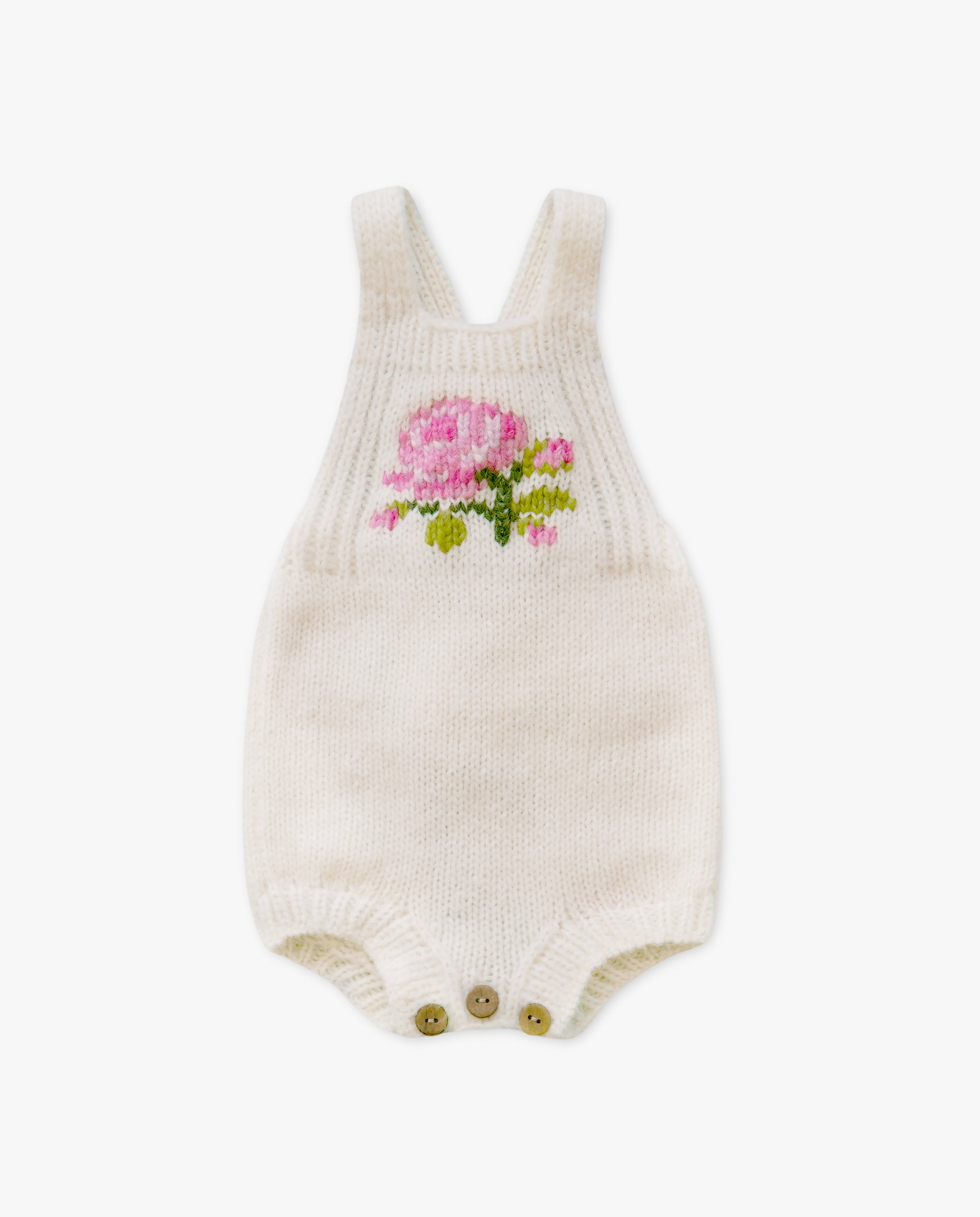 Knitted baby romper with floral design on a white background